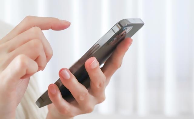 大田区葬儀相談室へ電話で連絡する手元のスマホを操作する様子、大田区　葬儀の相談受付窓口として