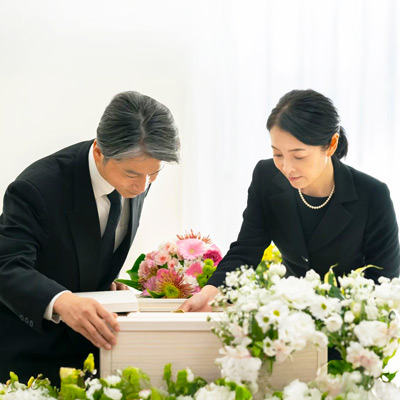 大田区葬儀相談室が家族葬で白い祭壇に棺を静かに整える遺族の様子、