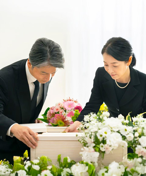 大田区葬儀相談室のスタッフが花に囲まれた小さな祭壇で遺族に寄り添う