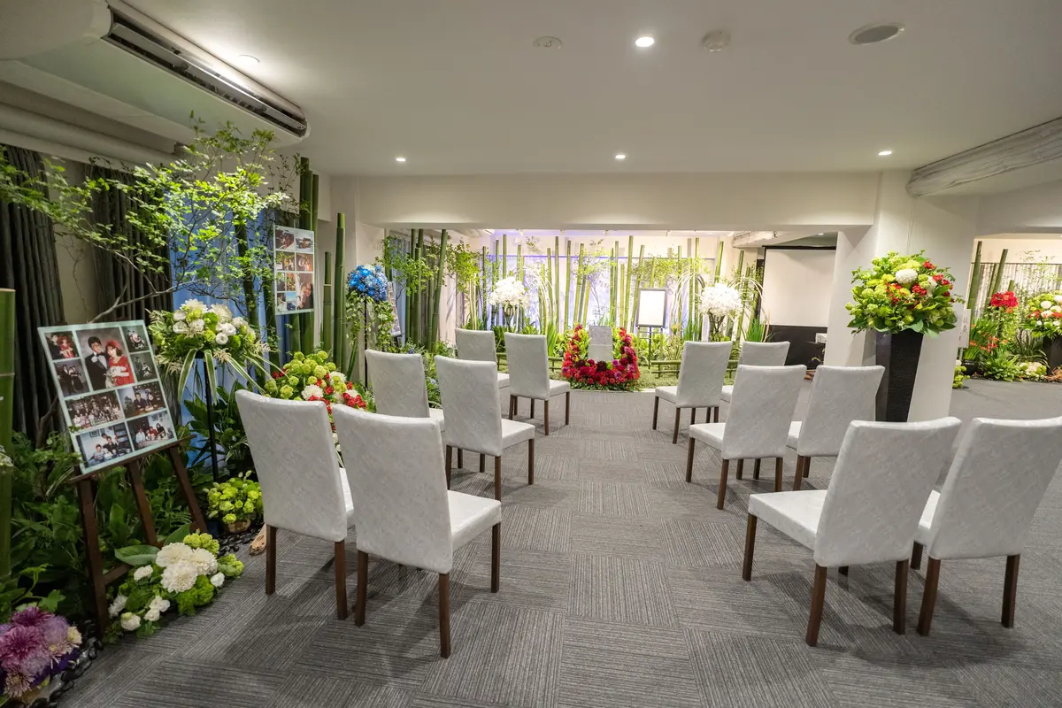大田区葬儀相談室が花いっぱいの祭壇を竹の背景で飾った式場の正面席配置
