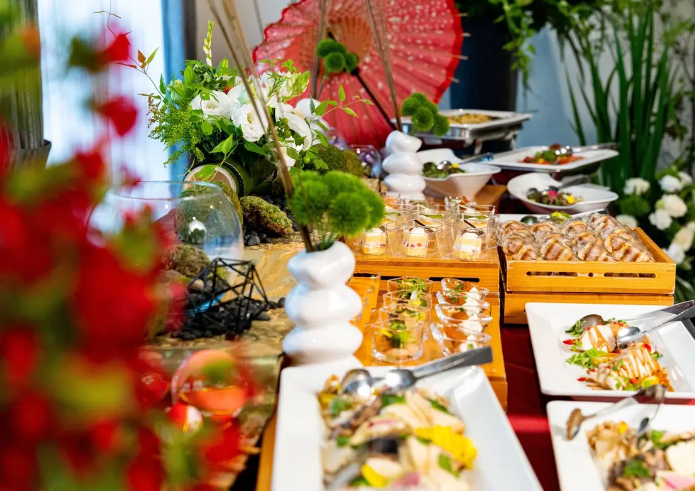 大田区葬儀相談室の会食テーブルに並ぶ和洋の葬儀用オードブルと会場装花