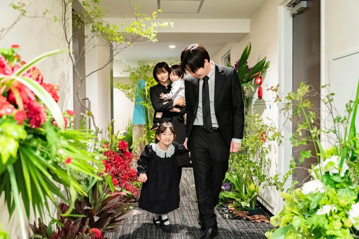 大田区葬儀相談室が花で彩られた式場を家族と共に歩く