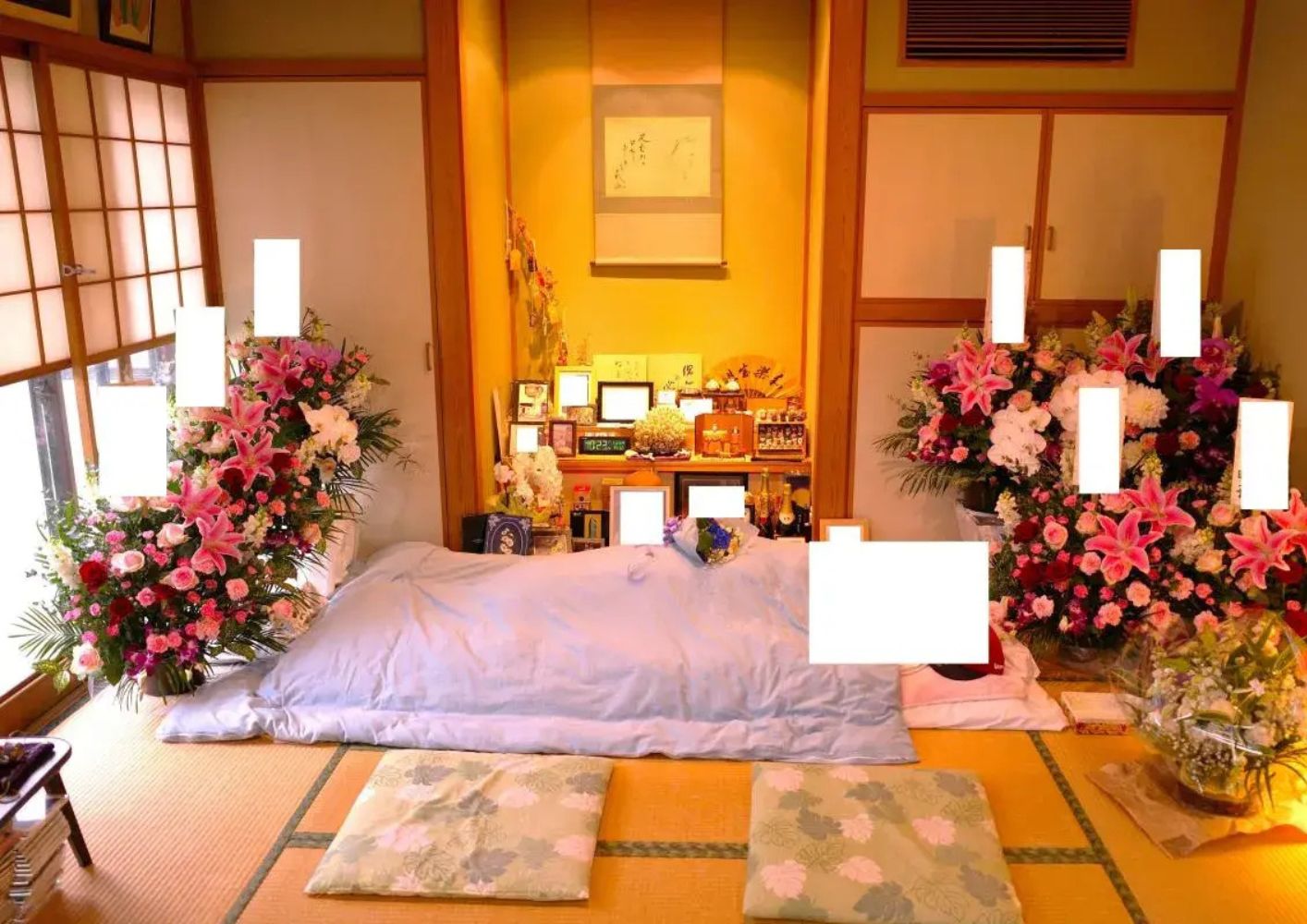 大田区葬儀相談室が大田区で祭壇と花に囲まれた遺族の枕飾りを整えている