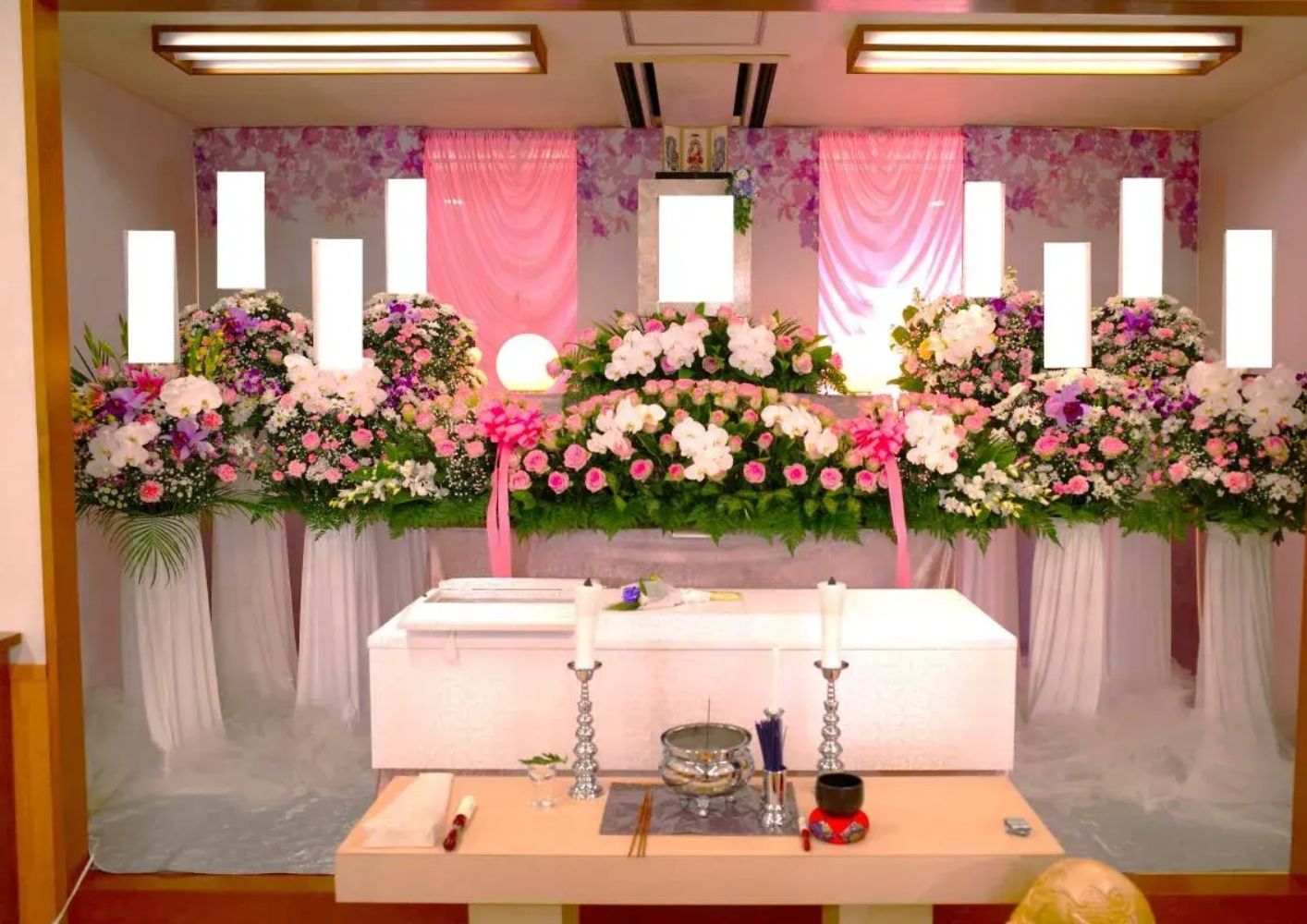 大田区葬儀相談室が大田区でピンク系の花を飾った葬儀祭壇を並べている