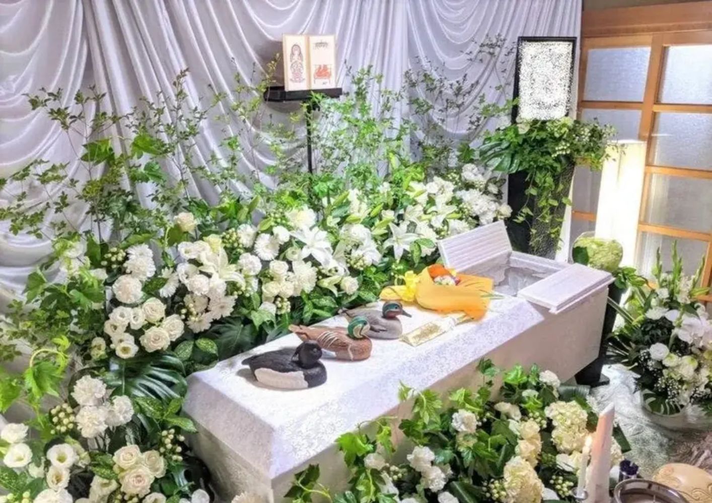 大田区葬儀相談室が大田区で白い百合とバラの生花祭壇を飾った葬儀場風景