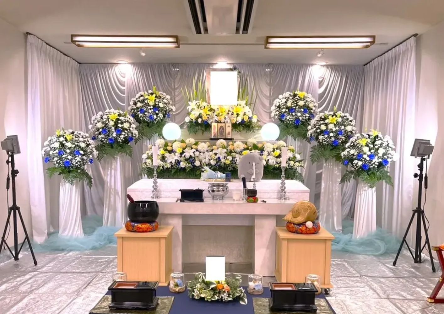 大田区葬儀相談室の一日葬祭壇に白と青の供花が並ぶ会場風景