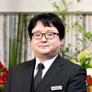 大田区葬儀相談室の黒スーツ姿で葬儀相談をする桑原侑希スタッフのポートレート