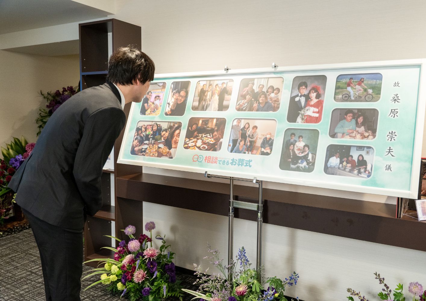 大田区葬儀相談室が提供する遺影パネルを男性が覗き込む大田区 葬儀の会場