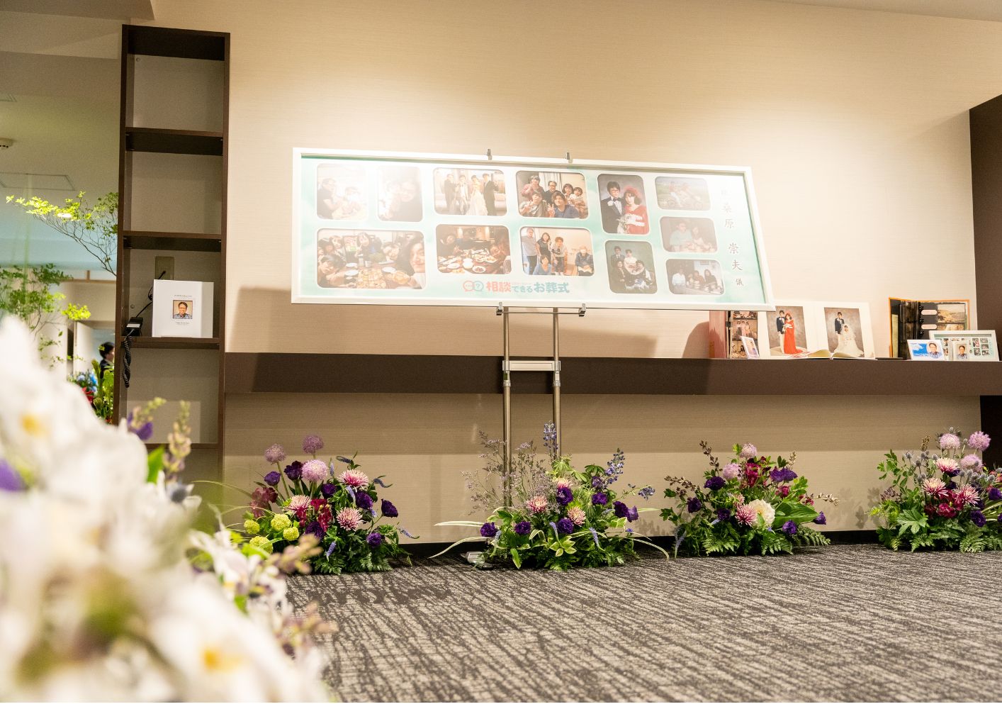 大田区葬儀相談室のご家族葬用写真ライブラリーと祭壇前に並んだ紫系の供花