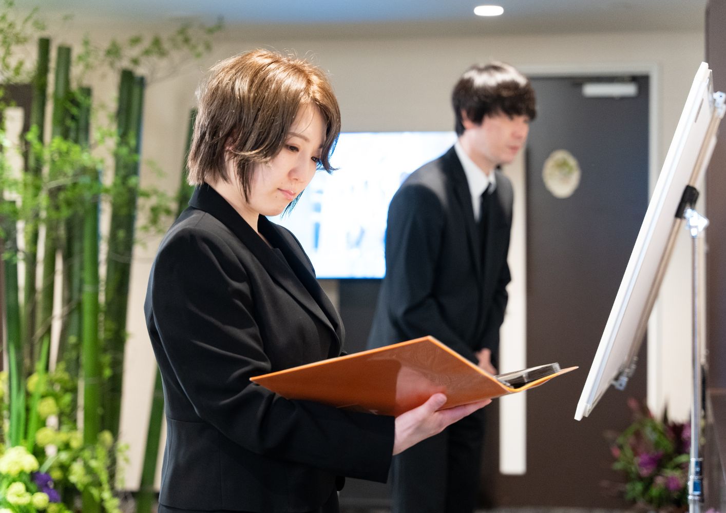 大田区葬儀相談室のスタッフが大田区 葬儀で受付台の資料を確認している
