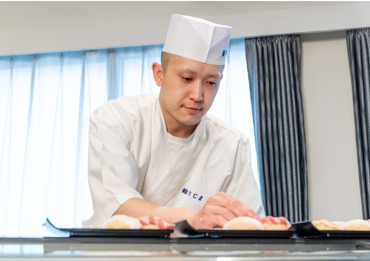 大田区葬儀相談室の寿司職人が祭壇前で盛り付けをする