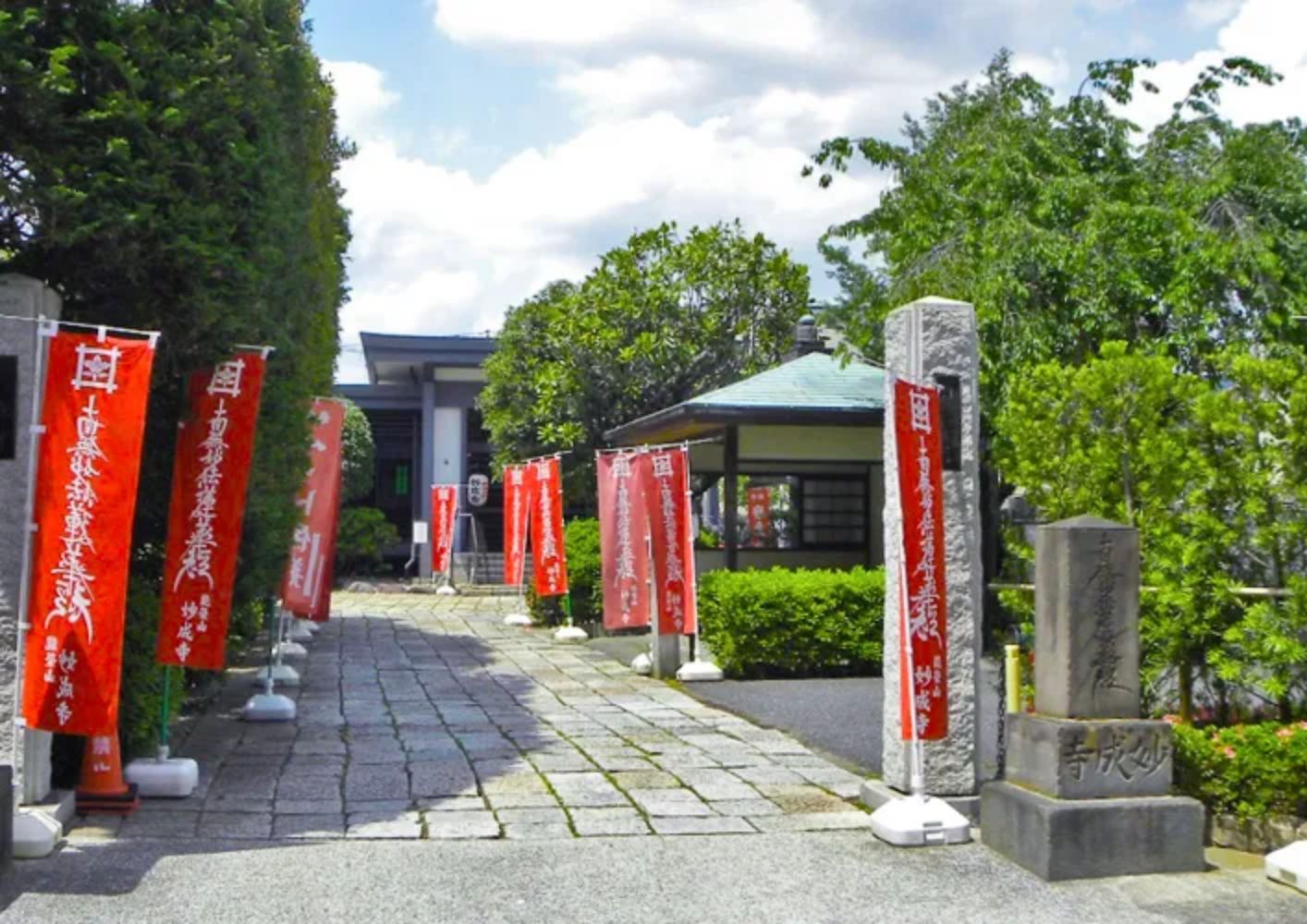 大田区葬儀相談室が蒲田の妙成寺前で赤い幟が並ぶ参道を案内する